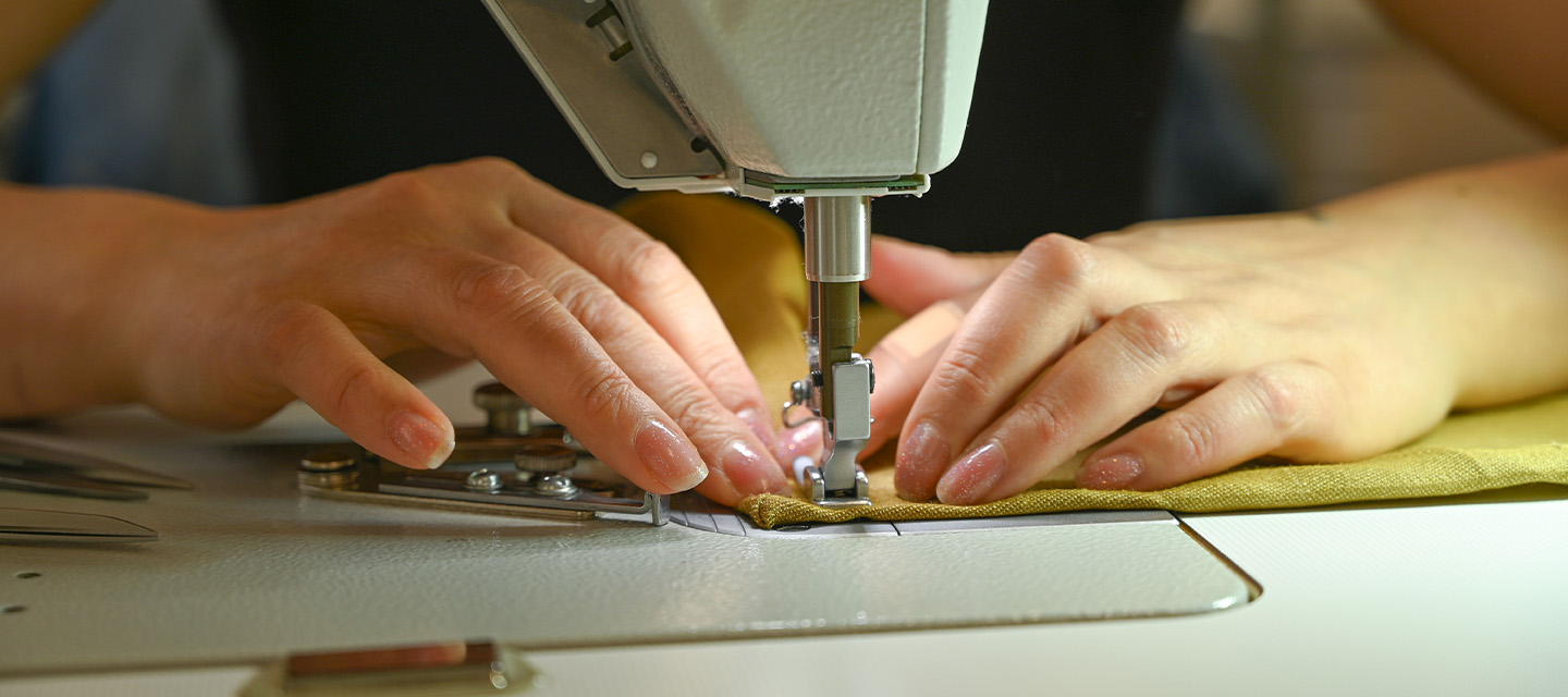 Manos de una costurera en la máquina de coser