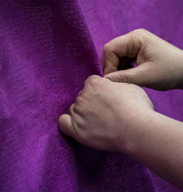 Manos sobre un tejido violeta